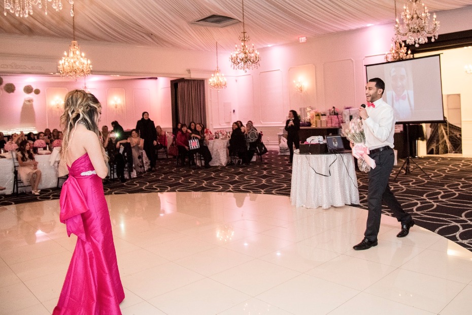 Man proposes to woman at elegant ballroom party