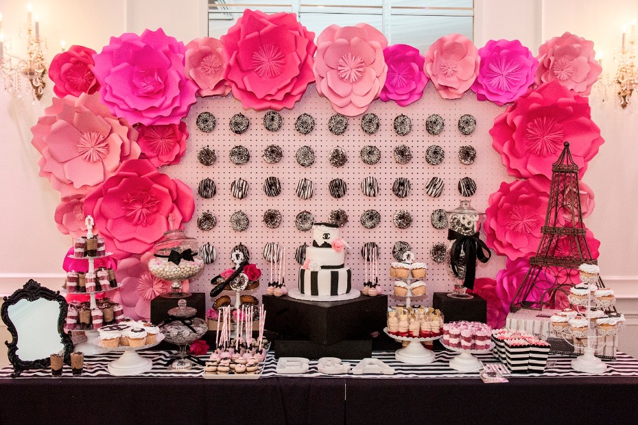 Paris themed party table with pink flowers and treats