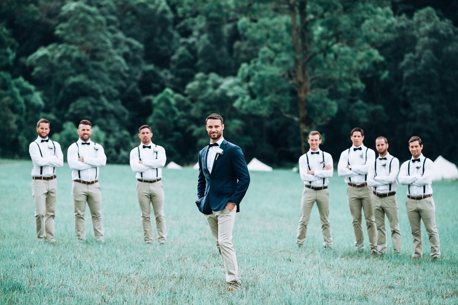 Stylish groomsmen in suspenders and bow ties