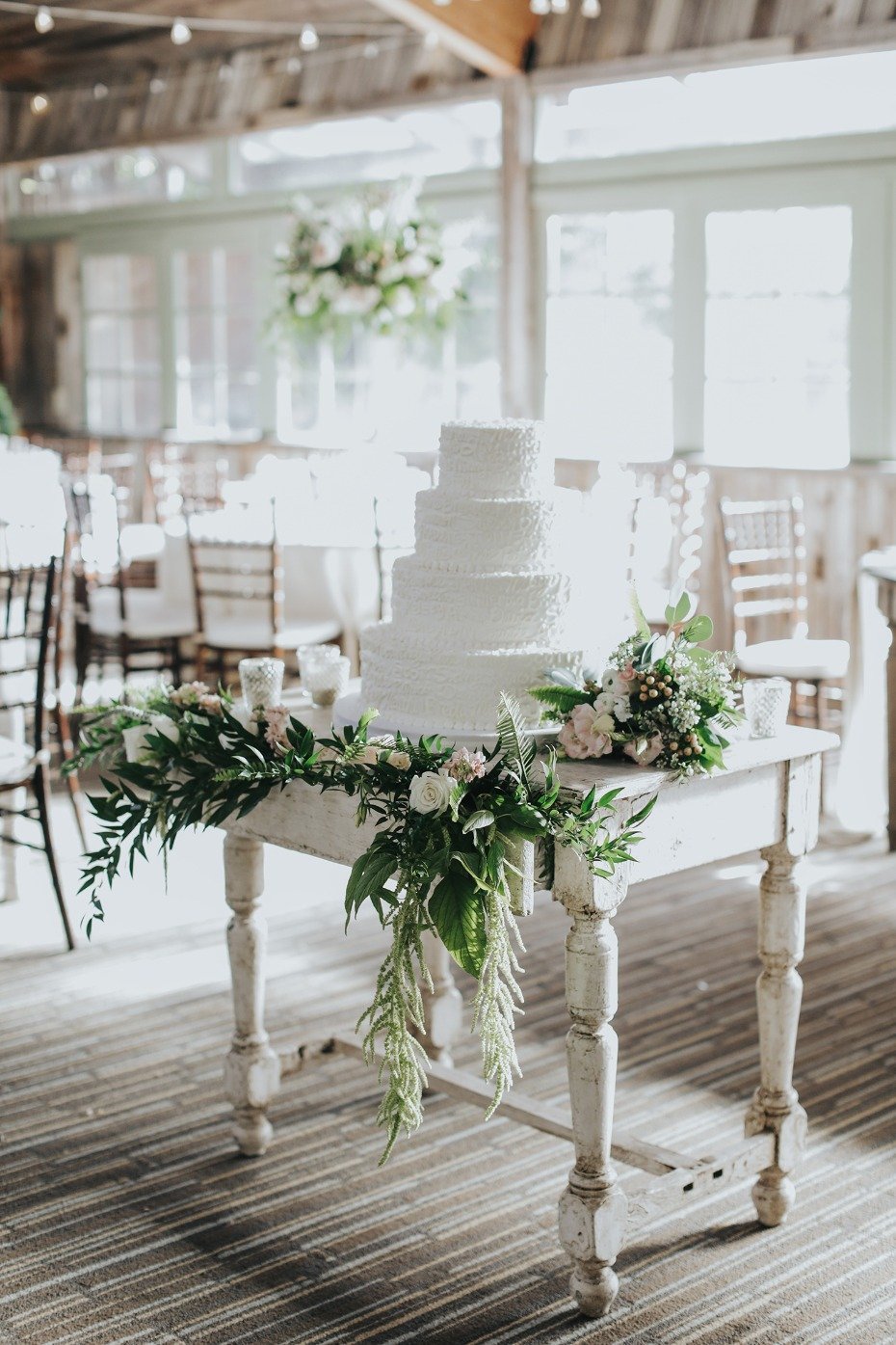 white wedding cake with cascading floral decor