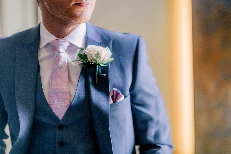 groom in blue suit with pink rose boutonniere