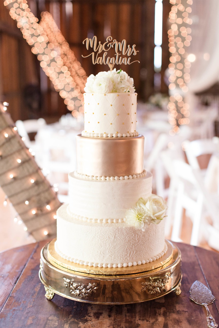 gold and white wedding cake on gold cake stand