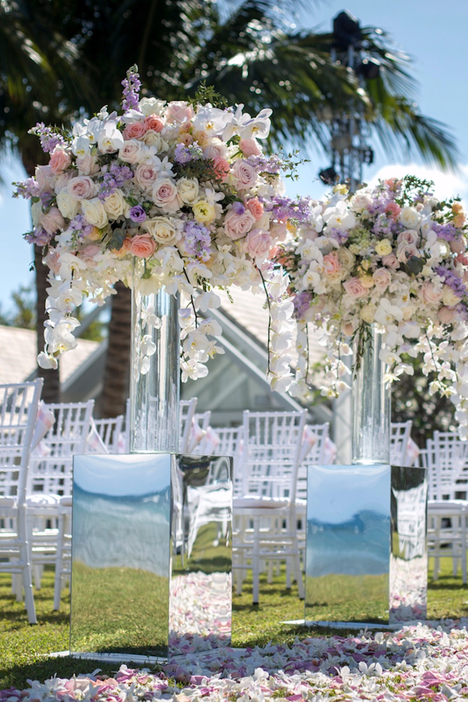 Floral wedding decor with white chairs and mirror pedestals