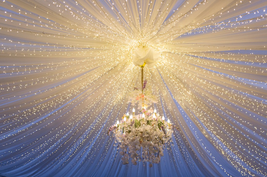 Elegant chandelier with fairy lights and draped fabric