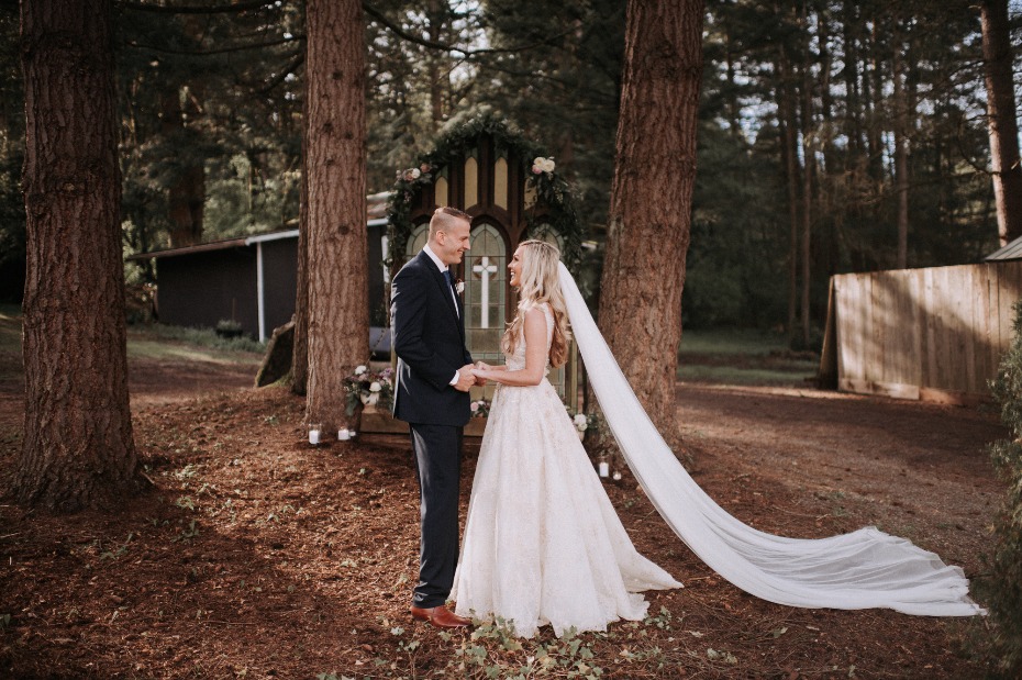 Woodsy outdoor ceremony with a vintage church window backdrop