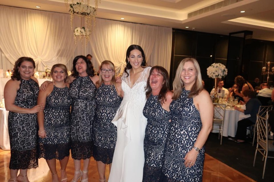 Bride with smiling bridesmaids at wedding reception