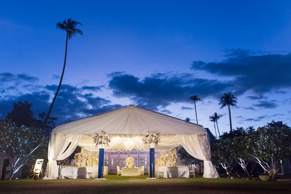 Elegant white tent wedding reception at twilight hour