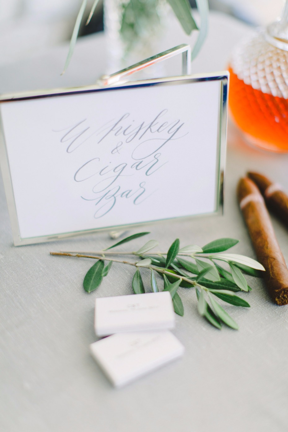 Whiskey and Cigar Bar sign with olive leaves and cigars