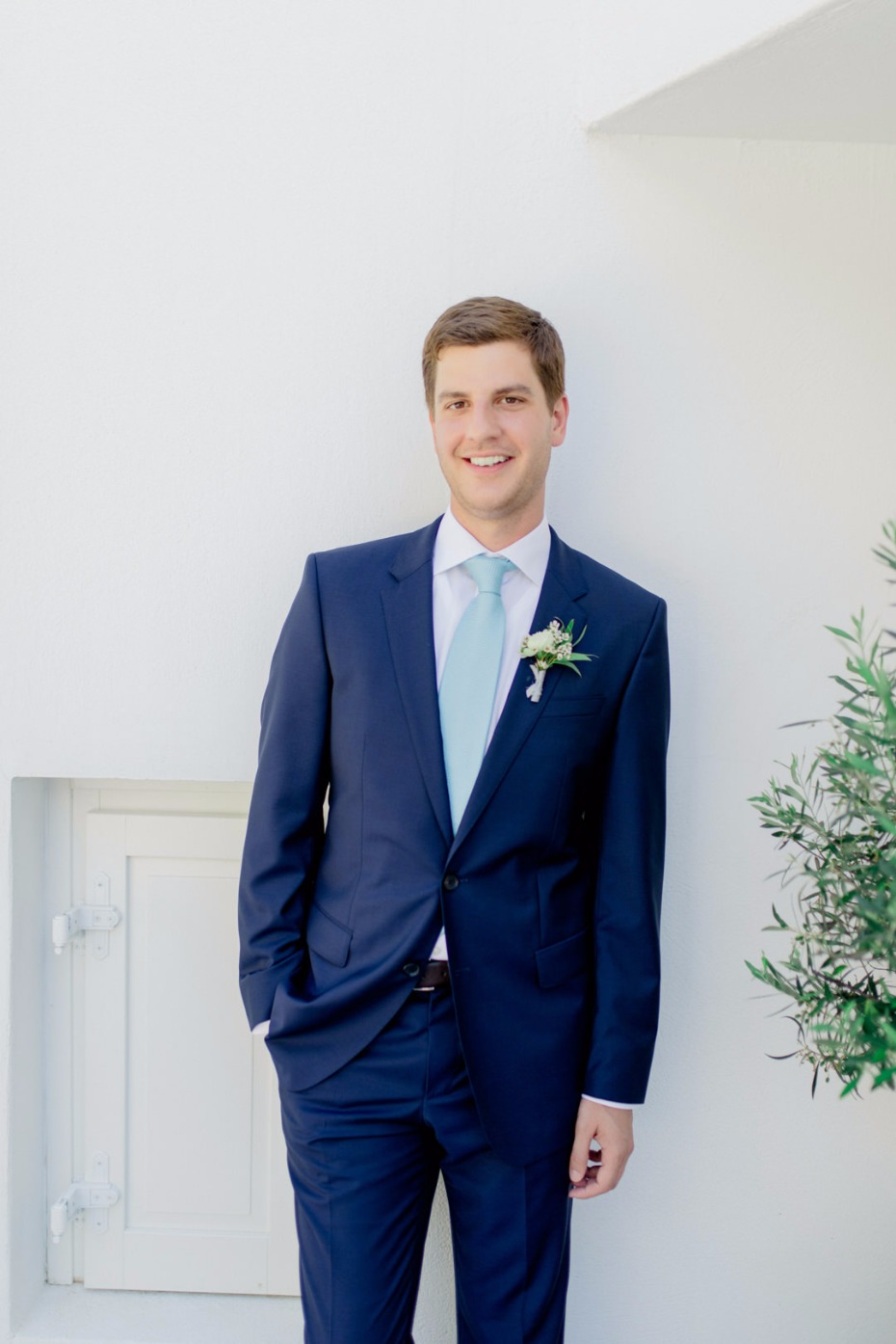 Happy groom wearing a navy blue suit on his wedding day