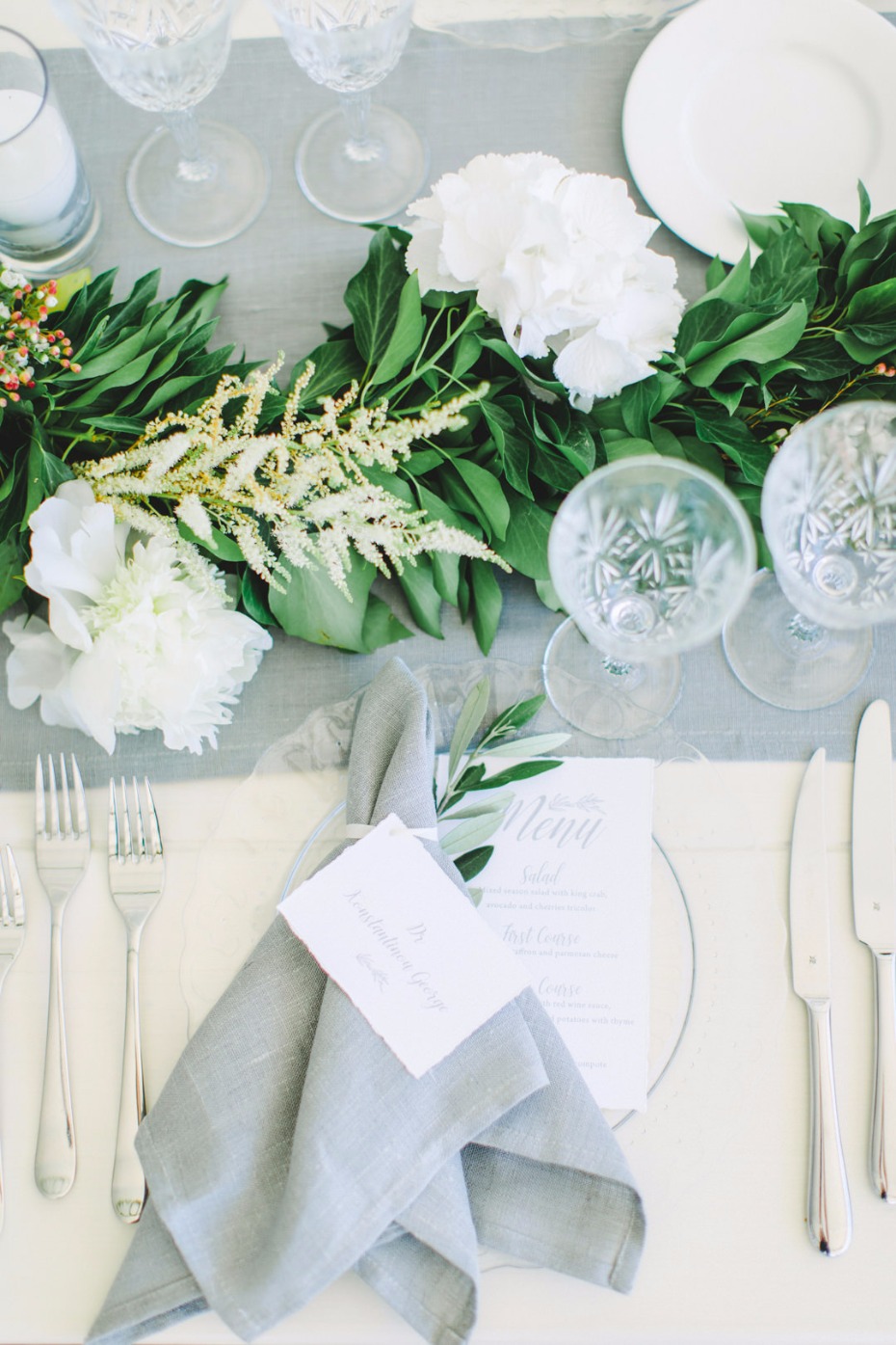 White and grey place setting with greenery