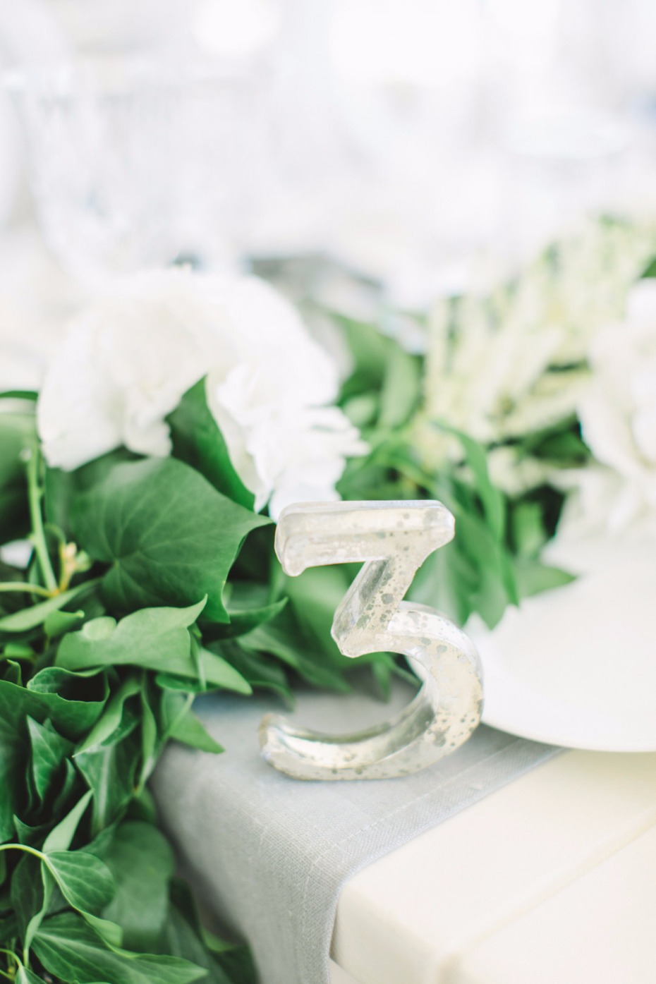 Elegant table number 3 surrounded by greenery and flowers