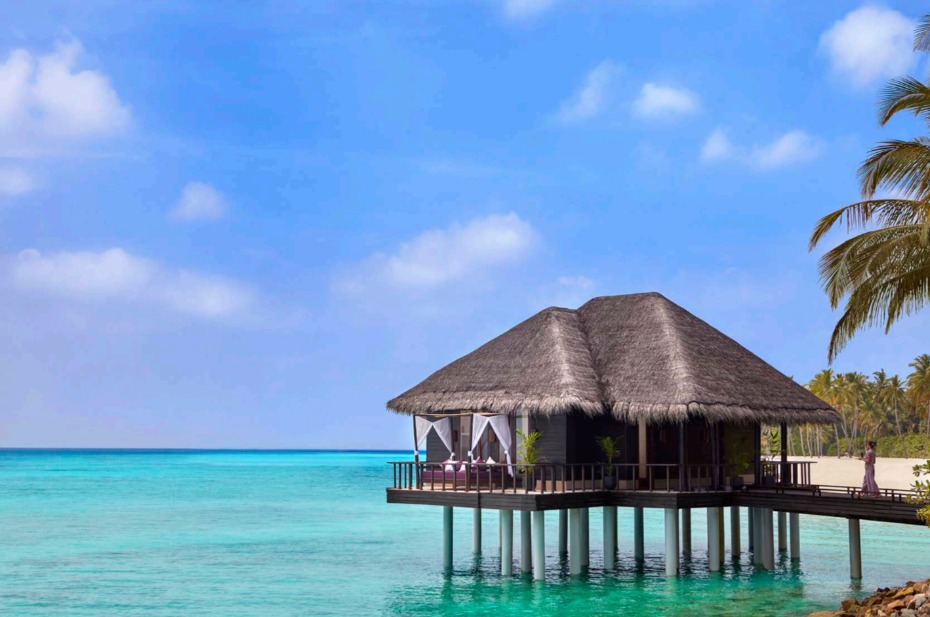 Overwater bungalow in turquoise tropical ocean paradise