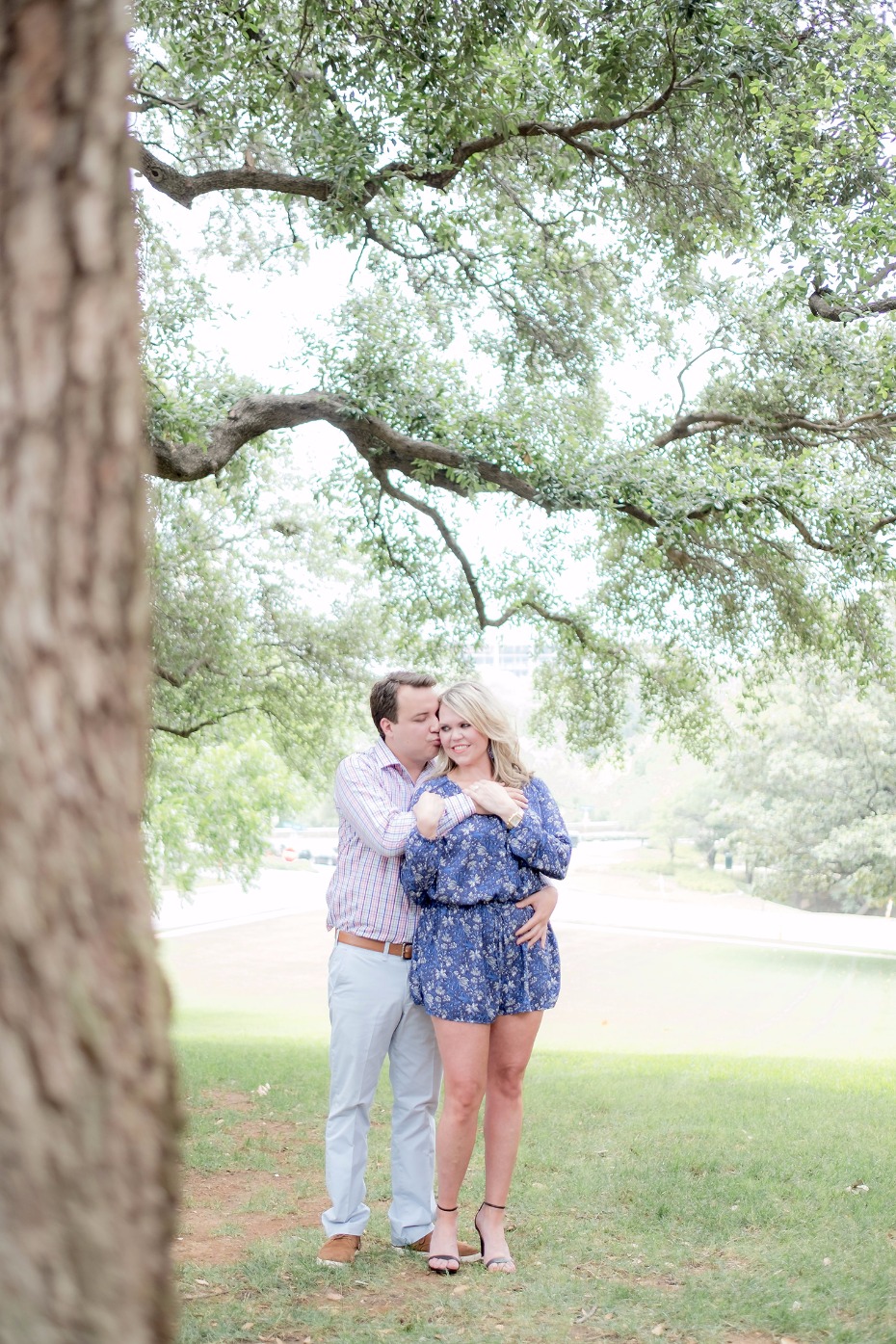 Couple embraces in a park, a tender moment under the trees