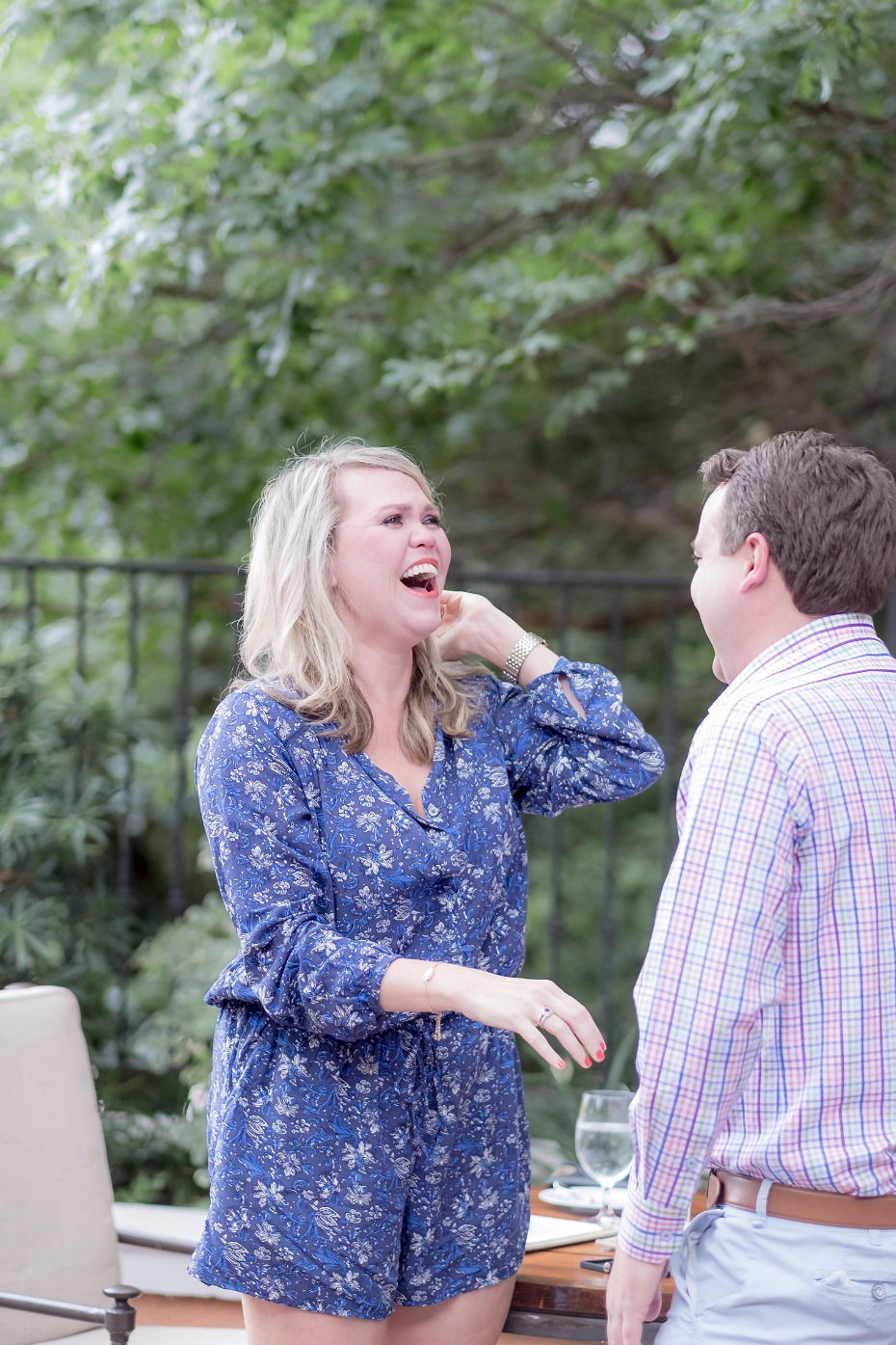 Woman in blue laughing with man in plaid shirt outdoors