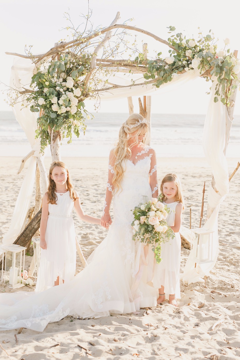 the bride and her flower girls at her elegant beach wedding ceremony