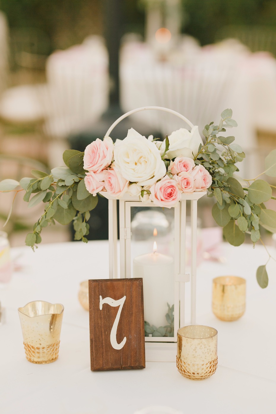 white lantern centerpiece with simple wooden block table number