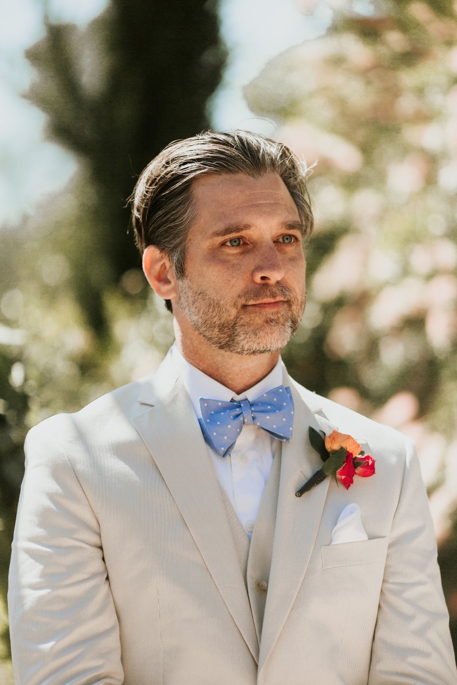 groom in tan suit and blue bow tie