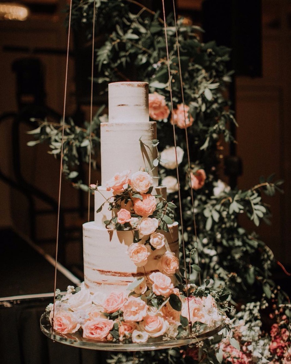 Elegant four-tiered wedding cake adorned with roses
