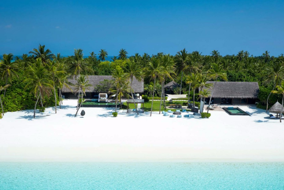 Maldives beach villas with palm trees and turquoise sea