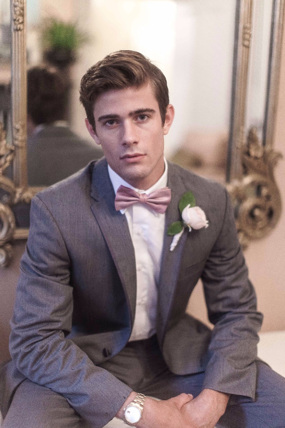 groom in pink bow tie and grey suit