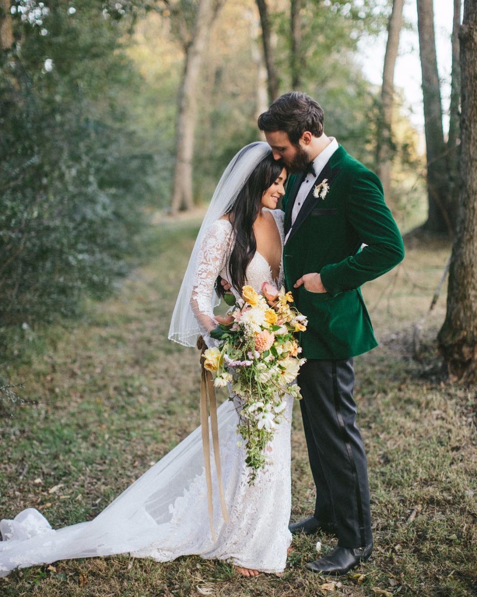 Bride and groom embrace in rustic forest wedding scene