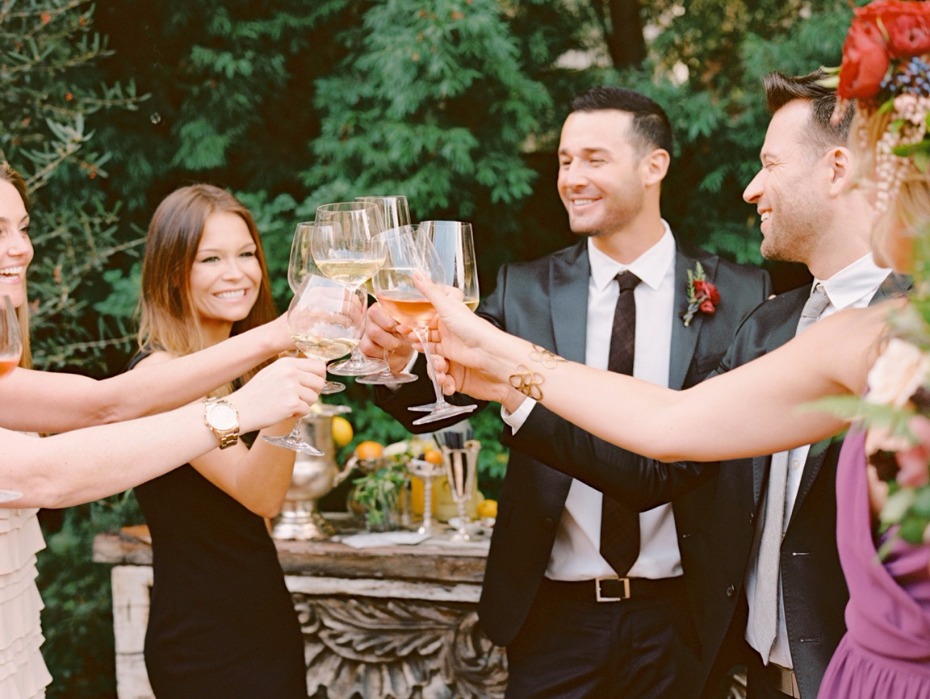 Wedding guests toasting with glasses of wine outdoors