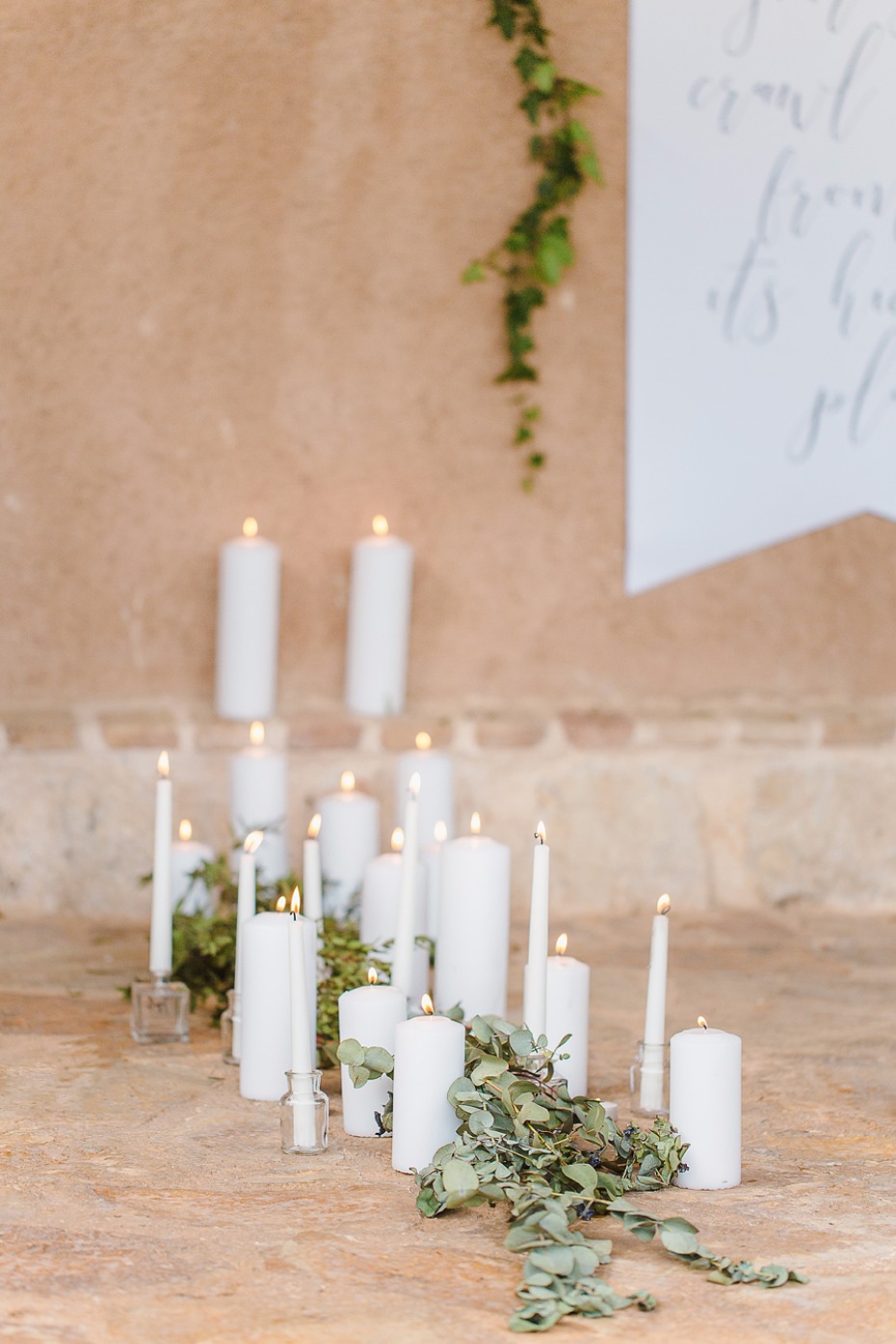 White candles and eucalyptus ceremony decor