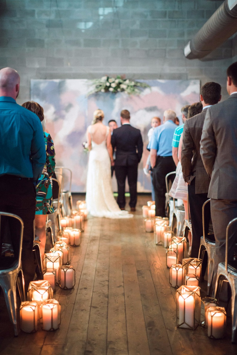 Candlelit wedding aisle with bride and groom at altar