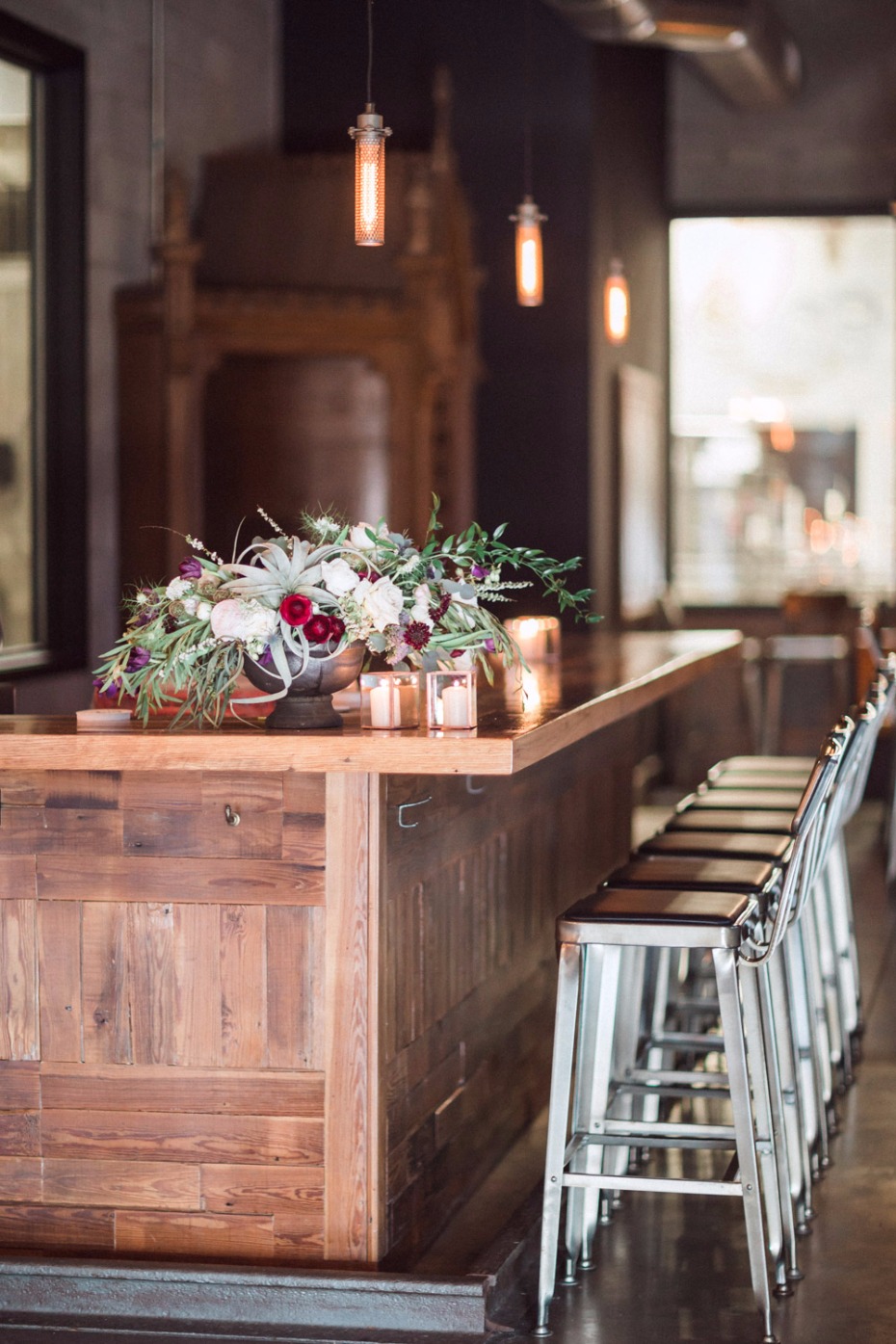 Rustic bar interior with floral arrangement and bar stools