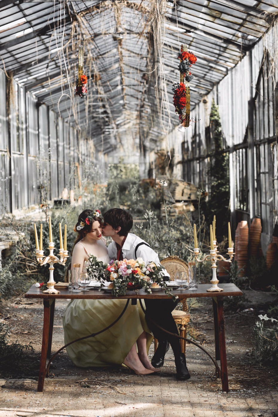 Couple sharing a romantic kiss at garden wedding table