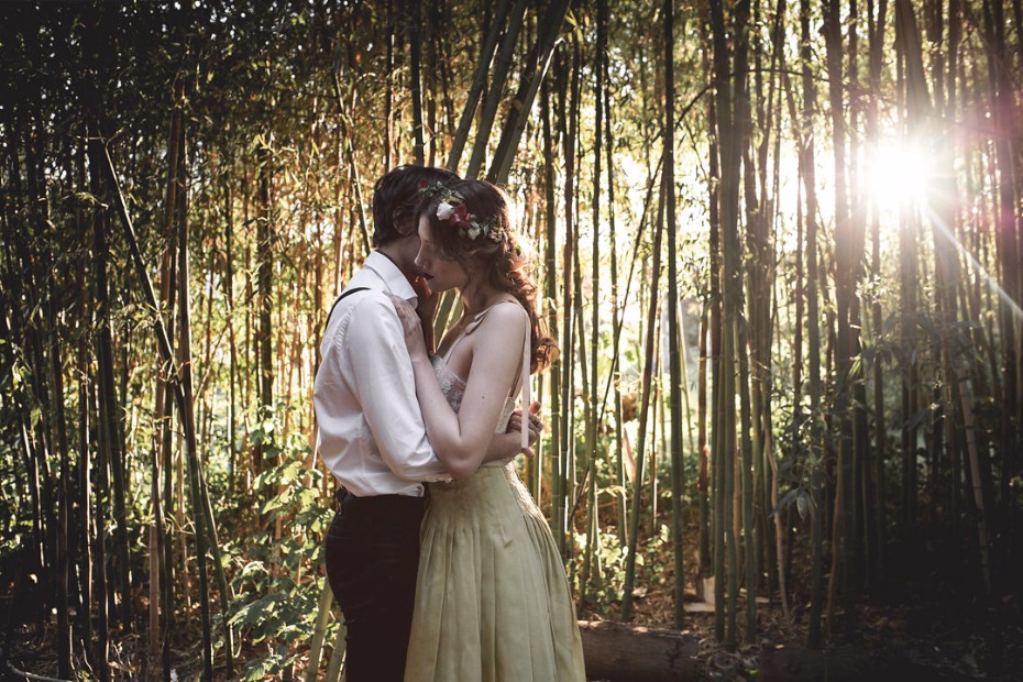 Romantic couple embraces in bamboo forest sunlight