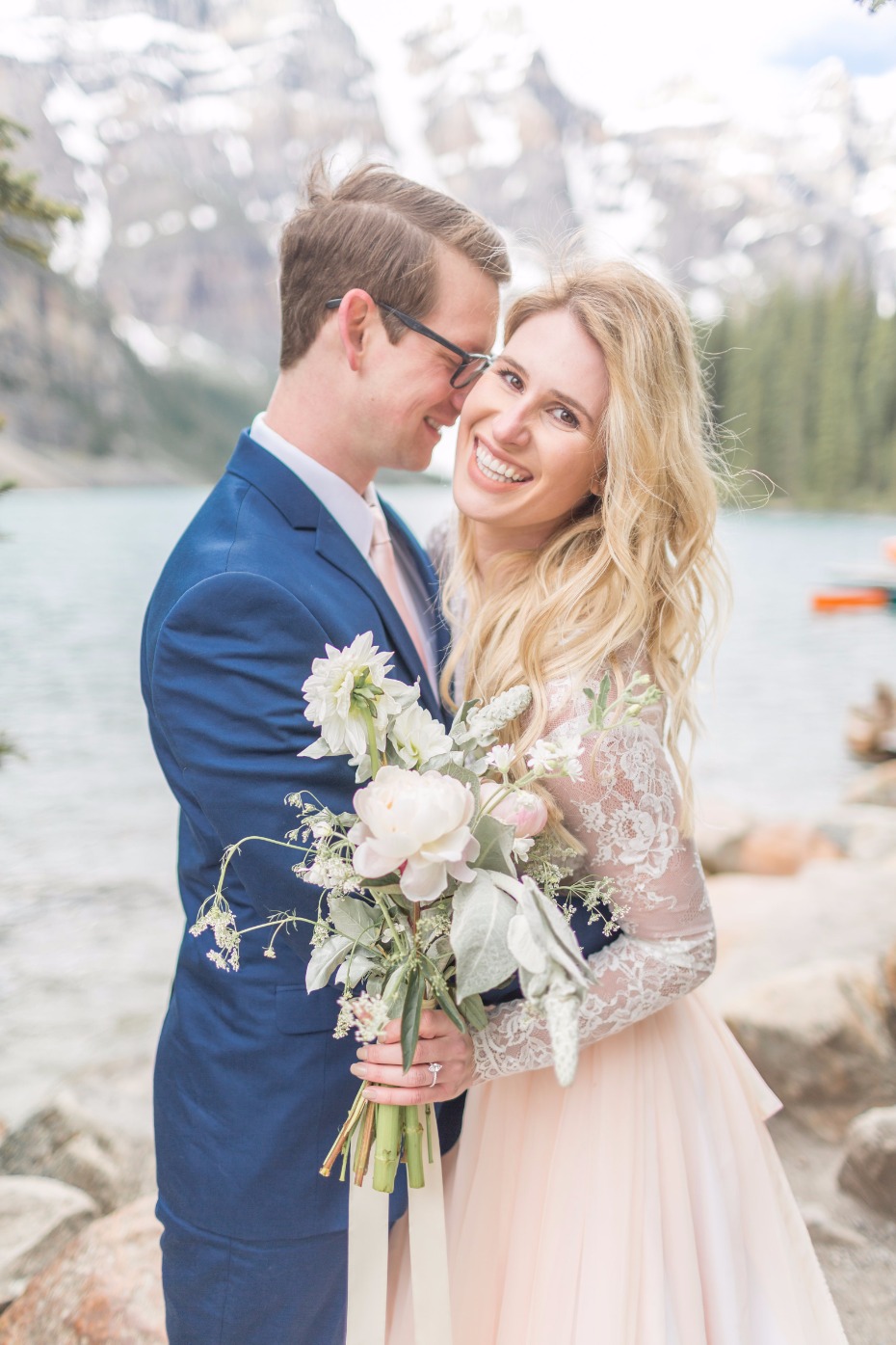 Happy couple smiles at their wedding day photoshoot by the lake