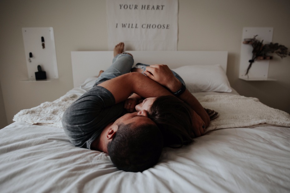 Couple cuddling in bed, showing affection