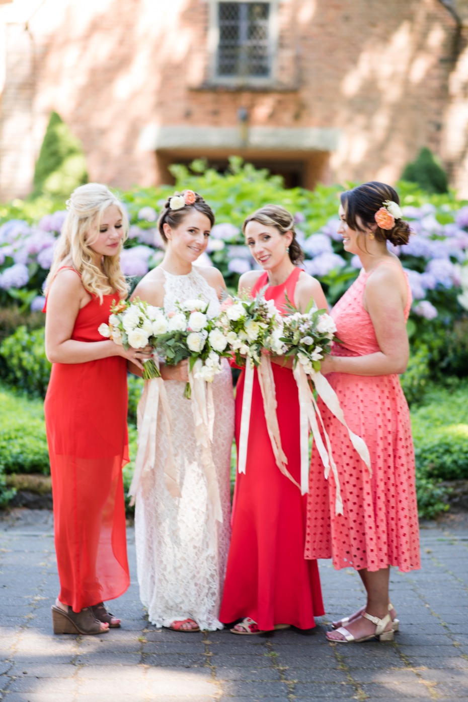 bride and her bridesmaids in varying shades of coral
