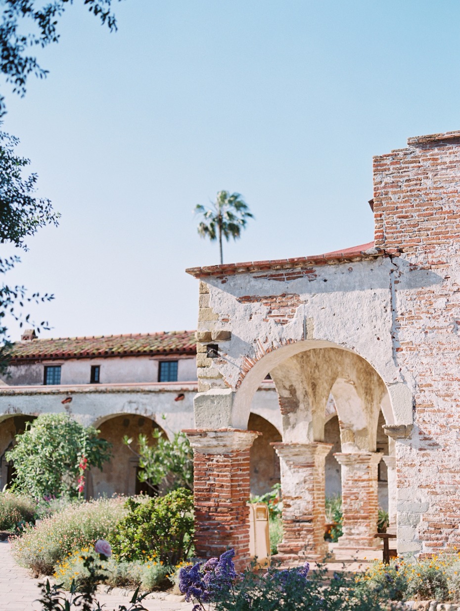 Historic mission courtyard with brick arches and lush garden