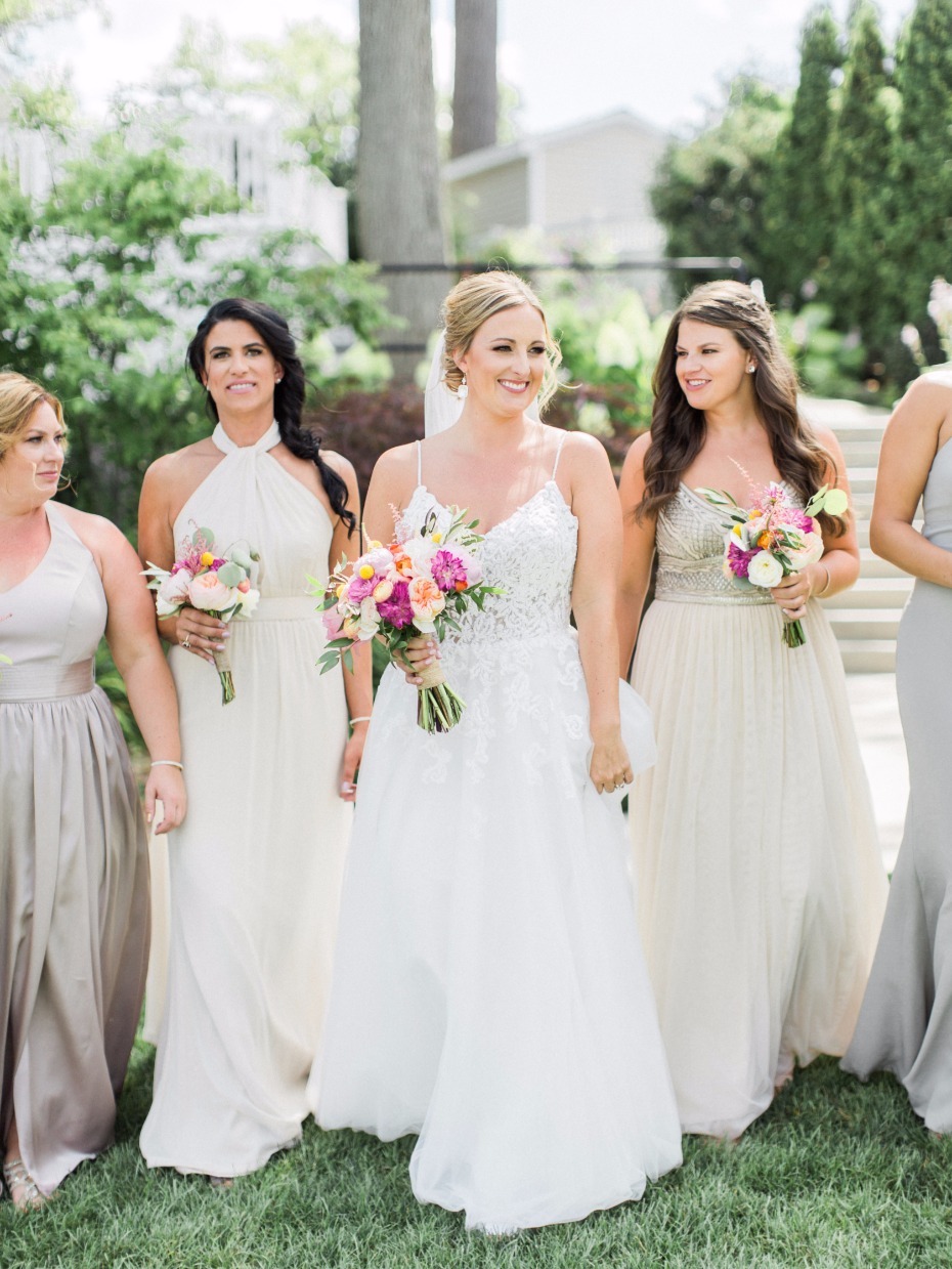 bride with bridesmaids in muted off white and grey dresses
