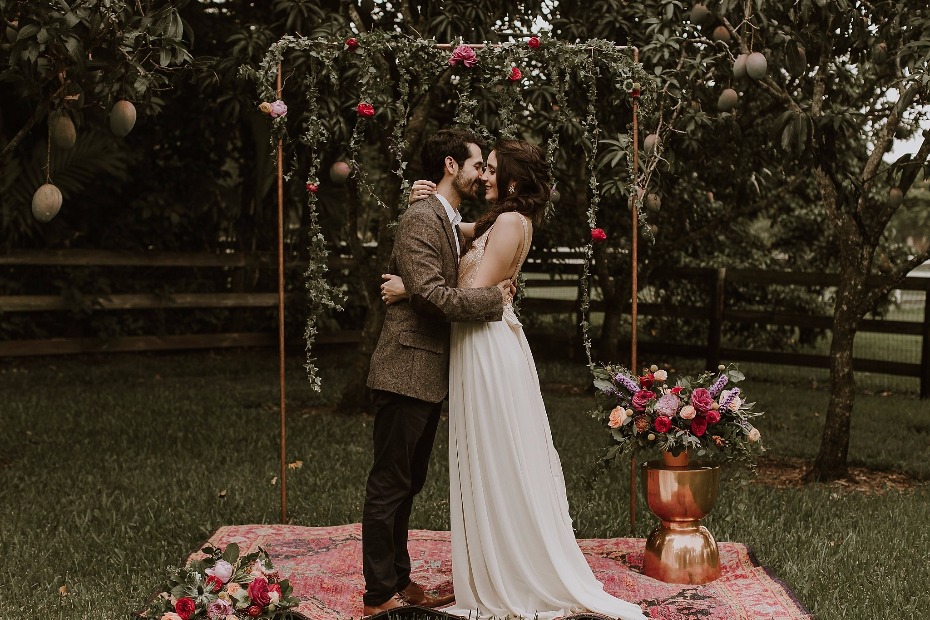 Colorful boho ceremony with rugs and gold