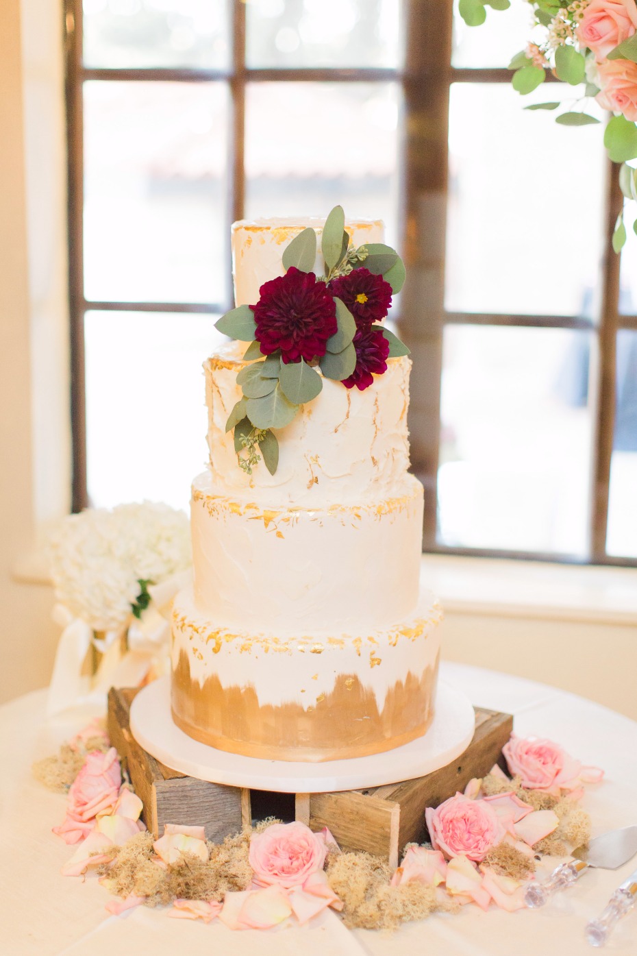 wedding cake with gold leaf and floral decor