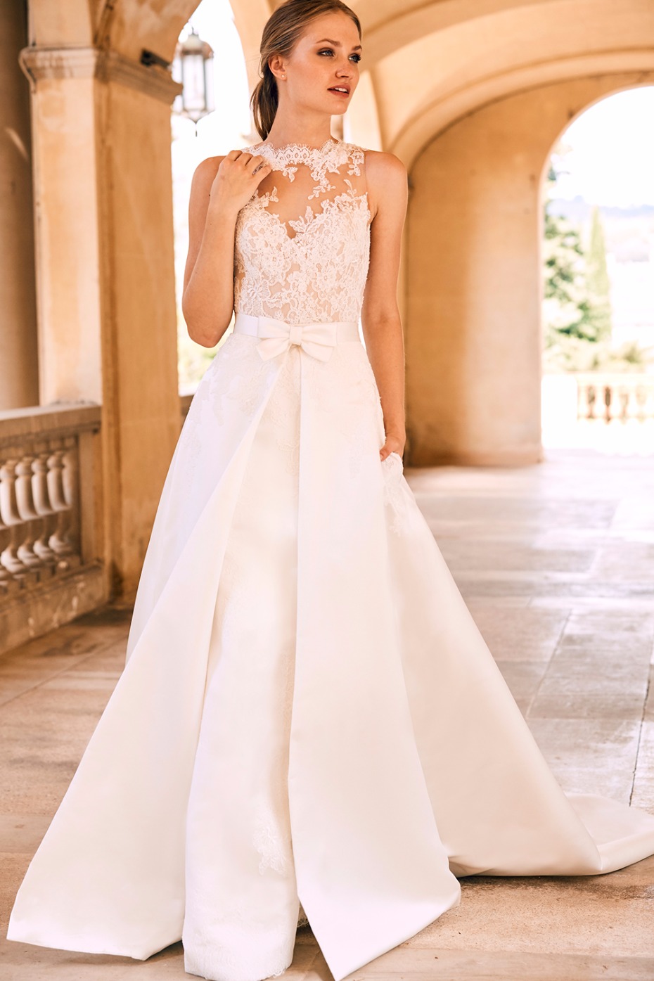 long wedding dress with detachable train and bow around the waist