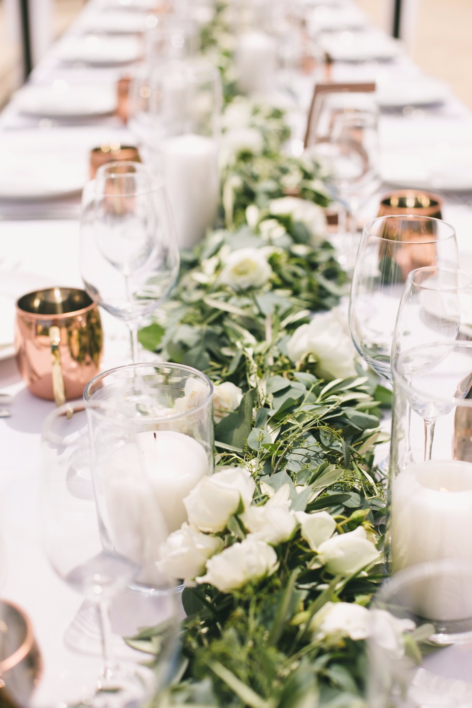 Greenery centerpiece with white candles and flowers