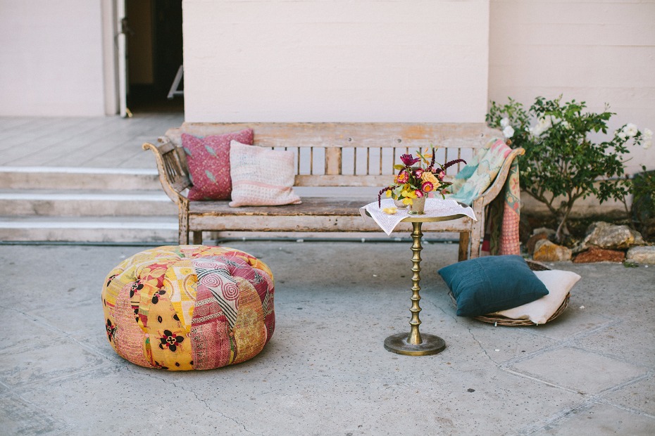 Bohemian outdoor seating with bench pouf and flowers
