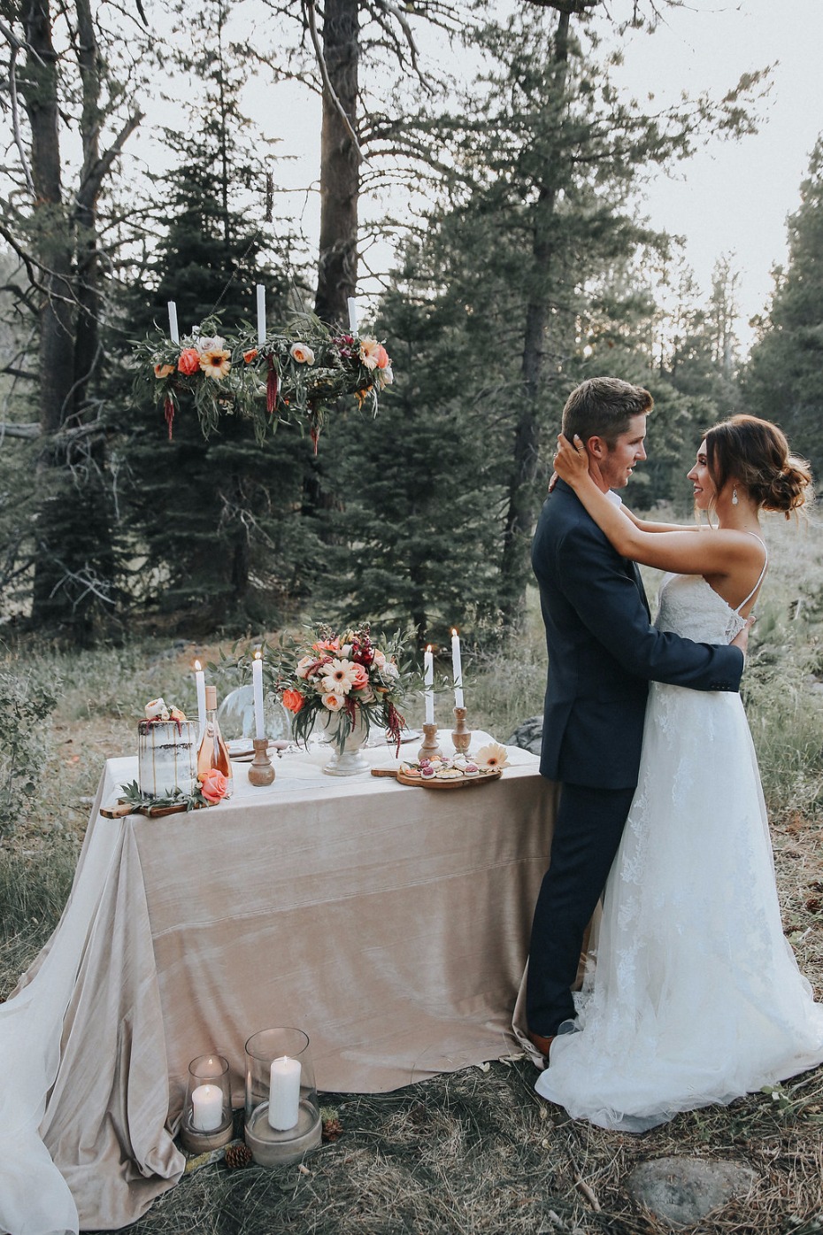 glamorous mountain sweetheart table with floral chandelier and plenty of candles
