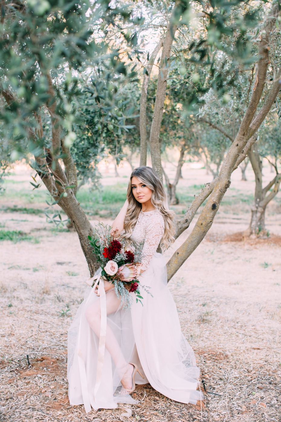 Elegant bride in wedding dress with bouquet outdoors