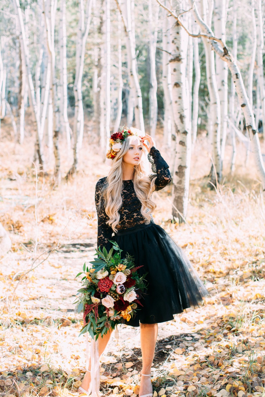Elegant bride in black dress with flower crown in forest