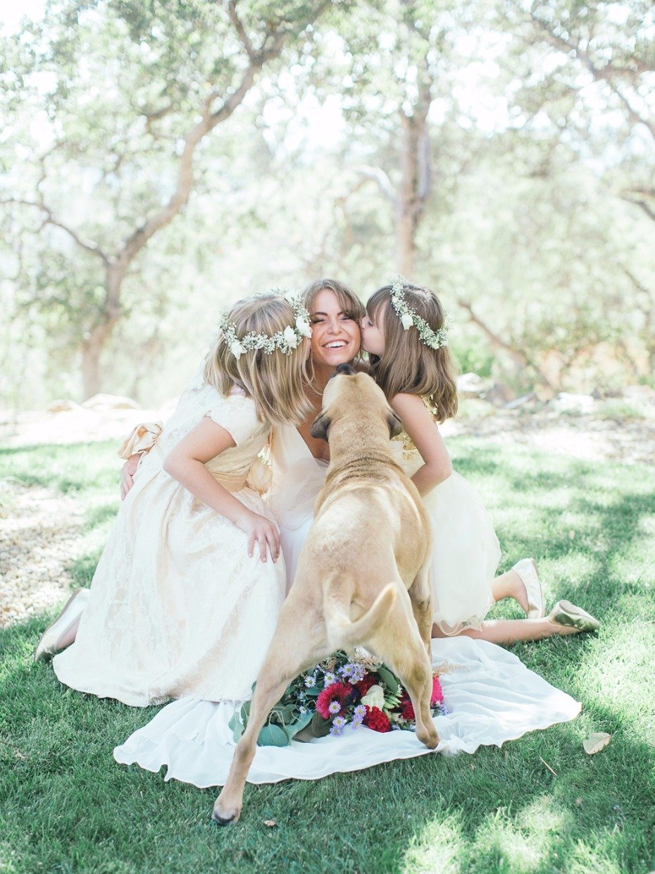 unexpected furry friend interrupts sweet flower girl and bride photo