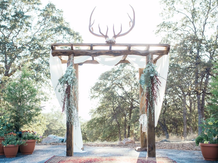 hand made wedding arch with antler rack and draped curtains