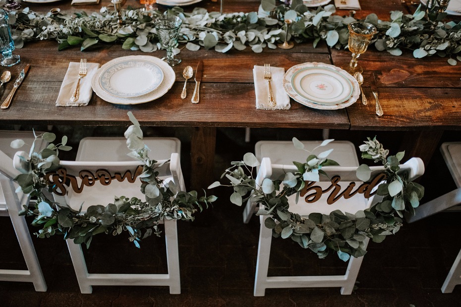 Groom and bride wood chair signs with eucalyptus