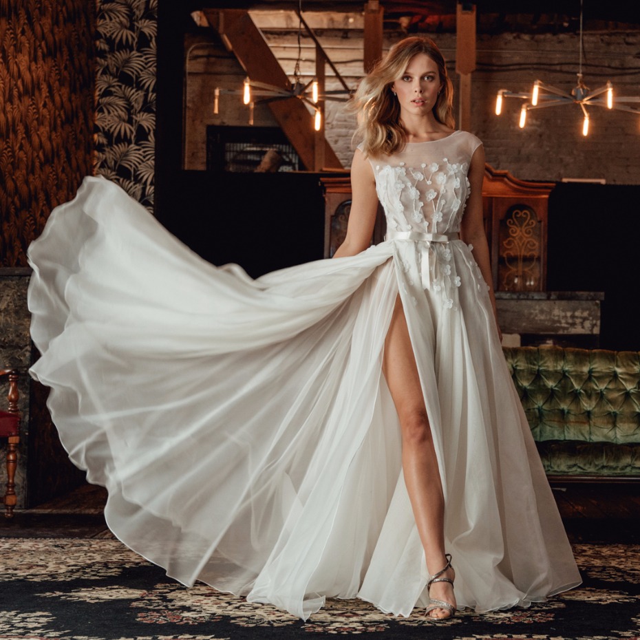 Woman in flowing white wedding gown with floral details