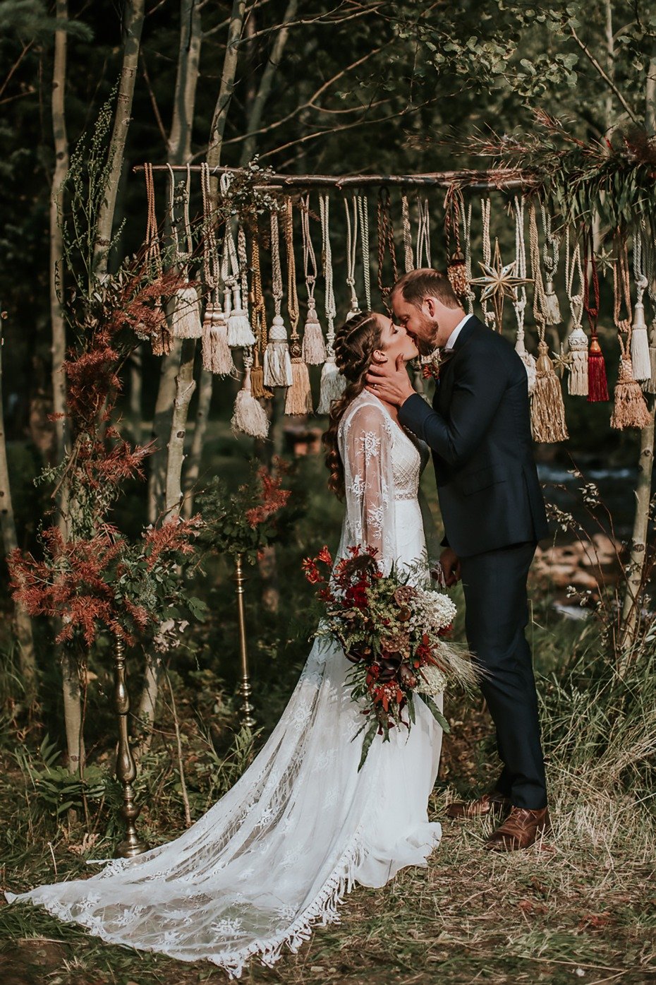 Rustic forest wedding with a vintage tassel wedding backdrop