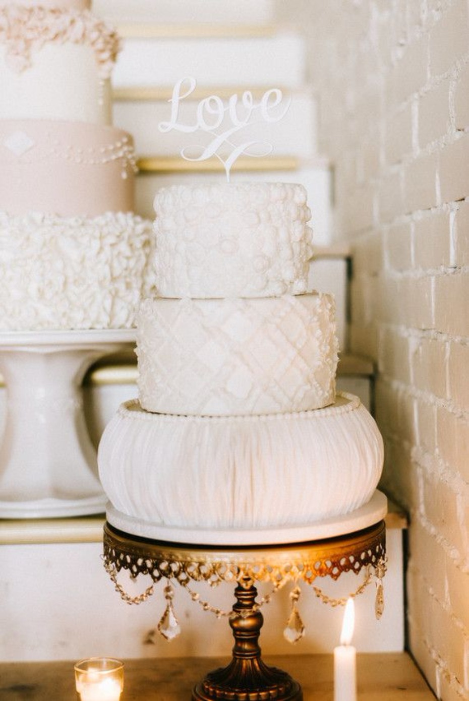 Elegant tiered white wedding cake with Love topper